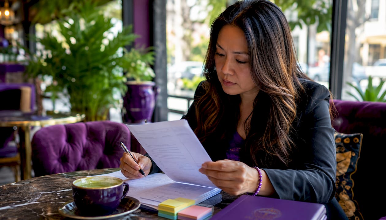 Woman reading supplement regulation document at desk