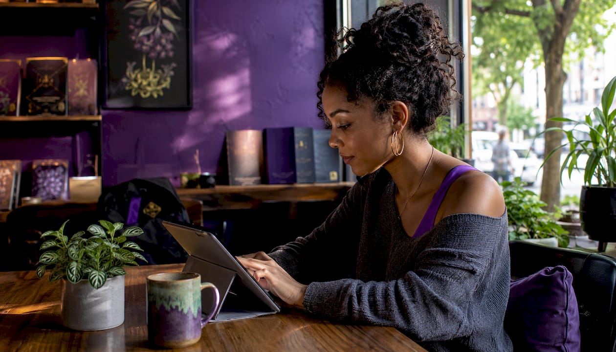 Young woman browsing wellness supplements at kitchen table
