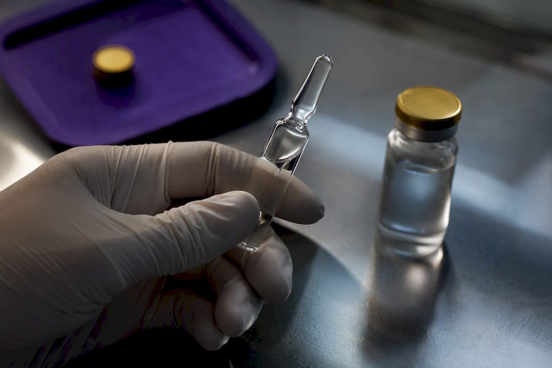 Researcher comparing sterile diluent containers